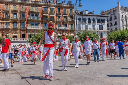 Pamplona, Spain: 09 July 2023: People celebrate San Fermin festival in traditional white abd red clothing with red necktie, Pamplona, Navarra, Spain.
