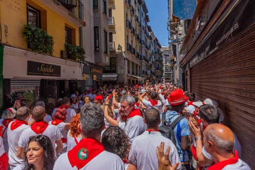 Pamplona, Spain: 09 July 2023: People celebrate San Fermin festival in traditional white abd red clothing with red necktie, Pamplona, Navarra, Spain.