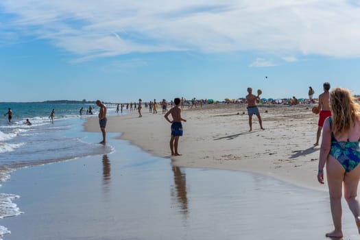 Tavira, Portugal - August 15, 2023: People at the famous beach of Tavira island in Tavira. This beach is a part of famous tourist region of Algarve.