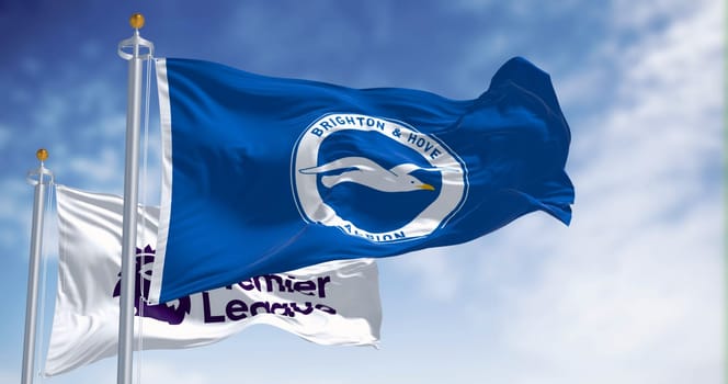 Brighton, UK, Dec. 23 2023: Brighton football club and Premier League flags waving in the wind on a clear day. Illustrative editorial 3d illustration render. Rippled fabric