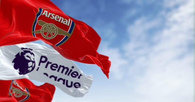 London, UK, July 18 2023: Arsenal Football Club and Premier League flags waving on a clear day. illustrative editorial 3d illustration render. Rippled Fabric. Selective focus