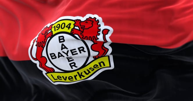 Leverkusen, DE, Nov. 2 2023: Close-up of Bayer Leverkusen flag waving. illustrative editorial 3d illustration render. Fluttering fabric. German Bundesliga Football club. Selective focus