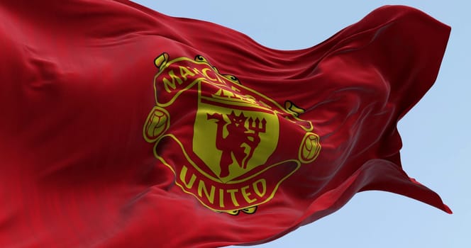 Manchester, UK, Oct. 2 2023: Close-up of Manchester United Football Club flag waving on a clear day. Premier League pro team. Illustrative editorial 3d illustration render. Selective focus