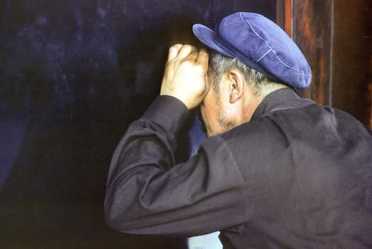 Beijing, Cina - July 10, 1984: old man in typical former chinese worker class dress looking at the window to the palaces of the forbidden city in Beijing