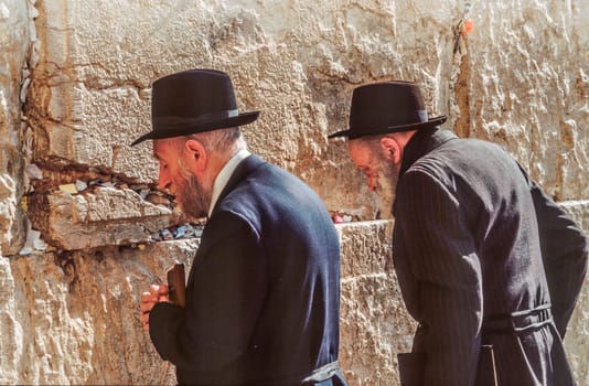 Jerusalem, Israel - January 1, 1995:   Orthodox jewish man prays at the Western Wall in Jerusalem, Israel. Israel's annexation of East Jerusalem in 1967, including the Old City, was never internationally recognized.