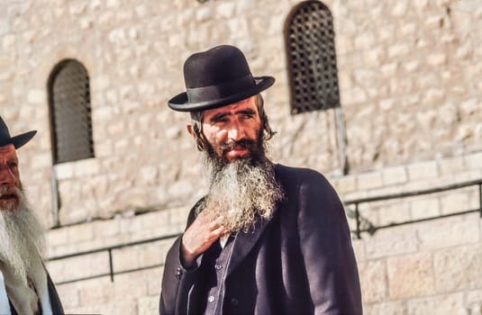 Jerusalem, Israel - January 1, 1995:   Orthodox jewish man prays at the Western Wall in Jerusalem, Israel. Israel's annexation of East Jerusalem in 1967, including the Old City, was never internationally recognized.