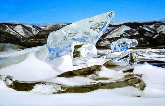 Frozen icicles of fresh water of lake Baikal. Winter on the Baikal, ice and snow on the lake. The beauty of the nature of Baikal in winter.