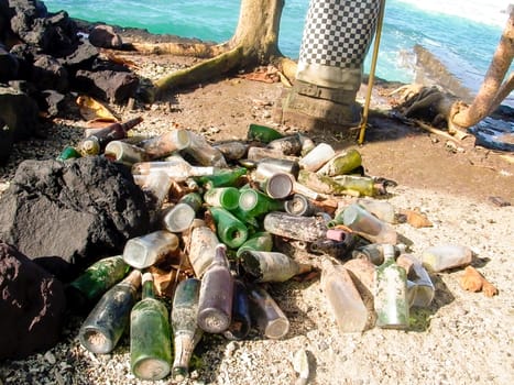 Candi Dasa, Indonesia - July 27, 2004: bottles after a party at the beach in Candi Dasa with a sacred palm tree.