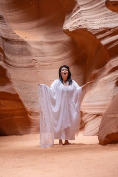 Antelope Canyon, USA - July 14, 2008: female musician sings in the slot canyon and enjoys the sound of the voice reflection.