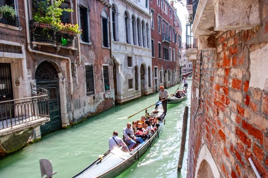Venice, Italy - September 23, 2005: people enjoy the gondola ride in the narrow canals in Venice, Italy.