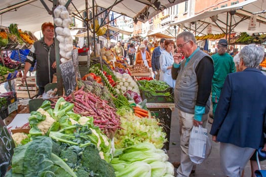 Venice, Italy - September 23, 2005: people enjoy buying fresh food at the farmers market in Venice, Italy.