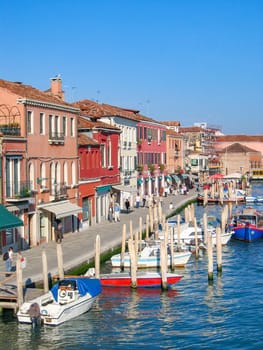 Venice, Italy - September 23, 2005: boats parking at the small pier in Burano, Venice, view to facade of houses at harbor, Italy
