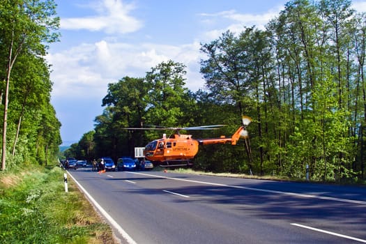 Bad Homburg, Germany - May 5, 2007: Helicopter is landing on the street to save and transport a seriously insured person by car accident to hospital in Bad Homburg, Germany