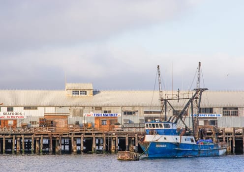 Monterey, USA - June 22, 2008: fishing boat at the historic wooden pier in Monterey with the fish market.