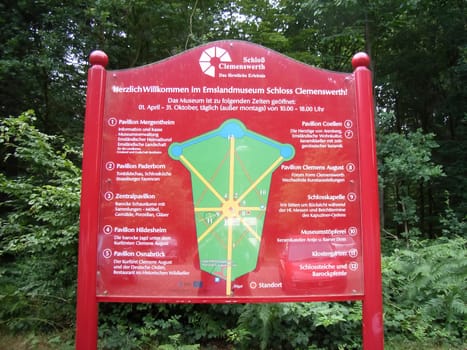 Clemenswerth, Germany - July 3, 2008: information sign with guideline where to go at castle Clemenswerth in Germany. The board shows map and entrance information in german.