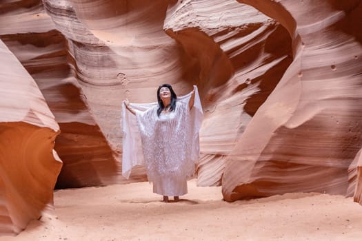 Antelope Canyon, USA - July 14, 2008: female musician sings in the slot canyon and enjoys the sound of the voice reflection.