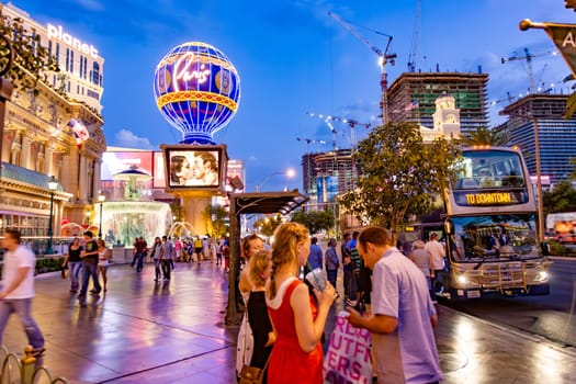 Las Vegas, USA - July 17, 2008: people at the strip in late evening with view to Paris globe and street with downtown bus.