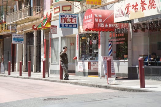 San Francisco, USA - July 24, 2008: view to Chinatown in San Francisco with a man using the mobile