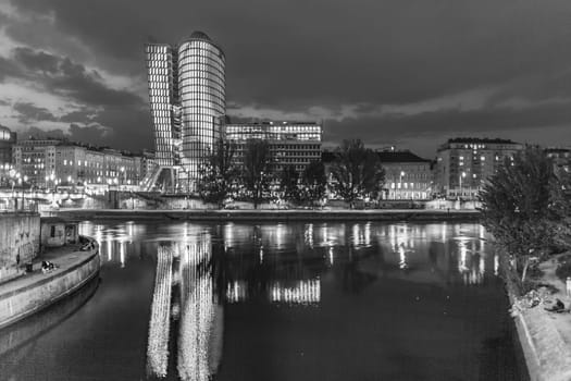 Vienna, Austria - April 22, 2009: reflection of Uniqa tower in Vienna by night in river Danube. The building received the European Union Green Building label as first building in Austria.