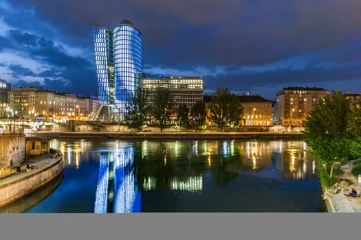 Vienna, Austria - April 22, 2009: reflection of Uniqa tower in Vienna by night in river Danube. The building received the European Union Green Building label as first building in Austria.