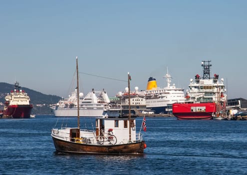 Bergen, Norway - July 4, 2009: ferry and old fishermans boat in the harbor of  Bergen, Norway, UNESCO world heritage site