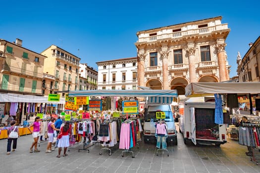 Vicenza, Italy - August 4, 2009: people go shopping at the market at the Piazza del Signori  in Vicenza, Italy. The palace was build by famous architect Andrea Palladio.