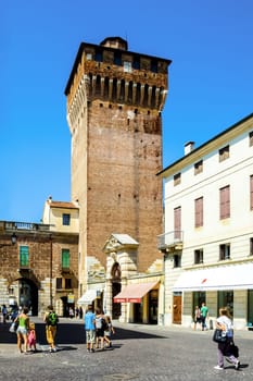 Vicenza, Italy - August 4, 2009: People walk along the place in front of old watch tower  Torre di Castello in Vicenza, Italy.