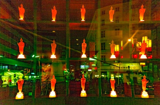 Vienna, Austria - December 5, 2009: colorful buddha statue in a shop with reflection of street light in glass window by night.
