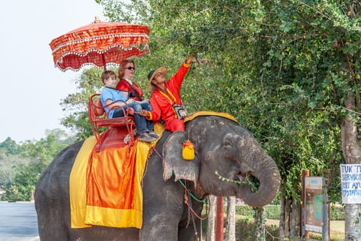 Ayutthaya, Thailand - December 24, 2009: tourists enjoy the elephant ride guided by a mahout in Ayutthaya.