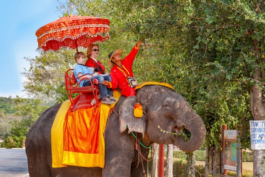 Ayutthaya, Thailand - December 24, 2009:  tourists ride on an elephant in the Historical Park in Ajutthaya, Thailand. It is called a must in Ayutthaya and costs about 1000 BATH for 30 min.