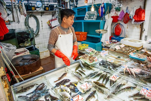 Hongkong, China - January 7, 2010: man selling frsh fish on ice at Fa Yuen street market, the market for fresh food.