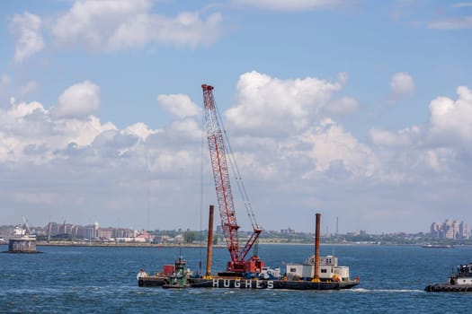 New York, USA - July 9, 2010: excavator ship Hudson at an offshore construction site installing iron pylons in the river bed of Hudson.