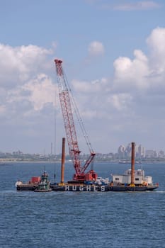 New York, USA - July 9, 2010: excavator ship Hudson at an offshore construction site installing iron pylons in the river bed of Hudson.