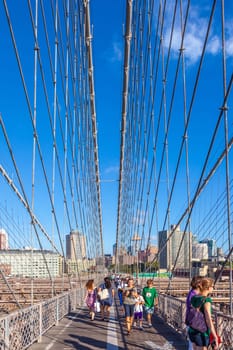 New York, USA - July 9, 2010: people crossing famous Brooklyn Bridge in New York.