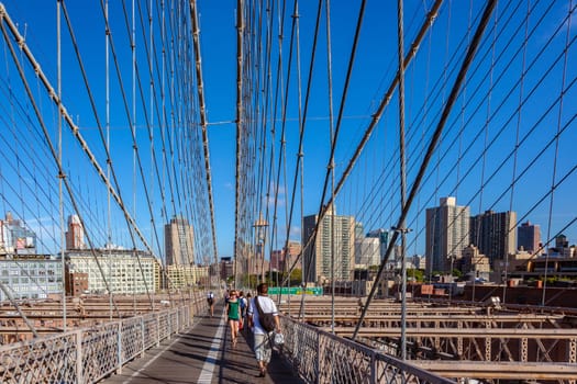 New York, USA - July 9, 2010: people crossing famous Brooklyn Bridge in New York.