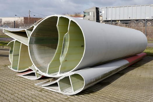 Cross-sections of the individual segments of a severed rotor blade of a wind turbine in a storage yard