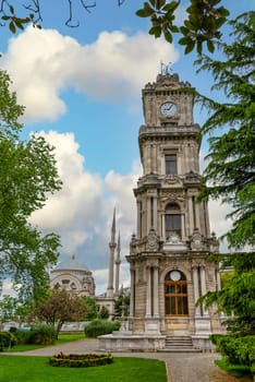 Morning shot of Dolmabahce Clock Tower, or Dolmabahce Saat Kulesi, situated outside Dolmabahce Palace, Istanbul, Turkey, with Baroque style Dolmabahce Mosque in the background