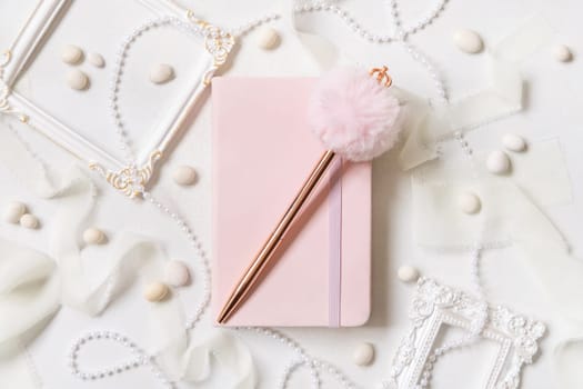 Pink school notebook, decorative gemstone pen and romantic decor on white top view. Textbook mockup. Dairy cover with place fot text. Valentines, educational and girly concept