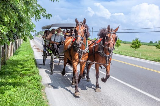 Lancaster, USA - July 13, 2010: Amish people ride in their horse carts in Lancaster, USA. Amish people don't use electricity as well as cars. They life the traditional way of the 17th century.