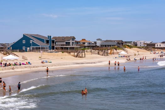 Nags Head, USA - July 18, 2010: people enjoy the beach at Nags Head, South Carolina. Beautiful wooden huts are along the beachside.