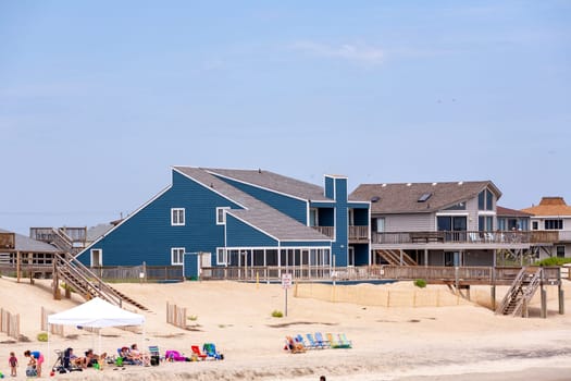 Nags Head, USA - July 18, 2010: people enjoy the beach at Nags Head, South Carolina. Beautiful wooden huts are along the beachside.