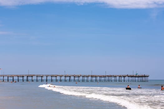 Nags Head, USA - July 18, 2010: people enjoy the old wooden pier beach at Nags Head, South Carolina.