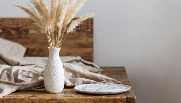 modern white ceramic vase with dry lagurus ovatus grass and marble tray on vintage wooden bench table blurred beige linen blanket in front scandinavian interior empty white wall copy space