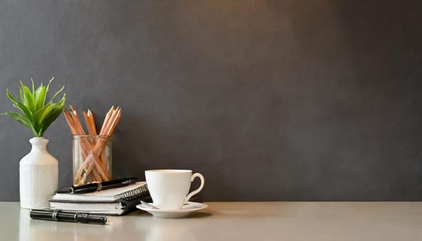 office table with copy space, stationery, vase, and lamp.