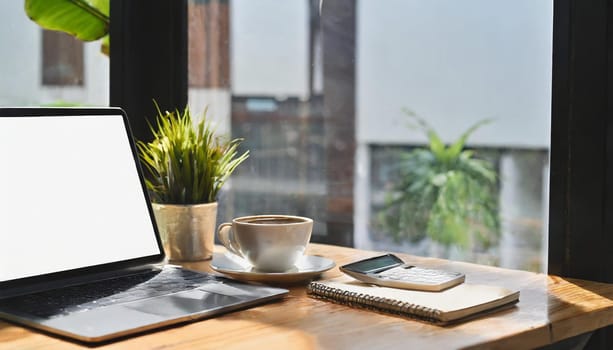 Modern workplace with laptop computer, coffee cup and office supplies