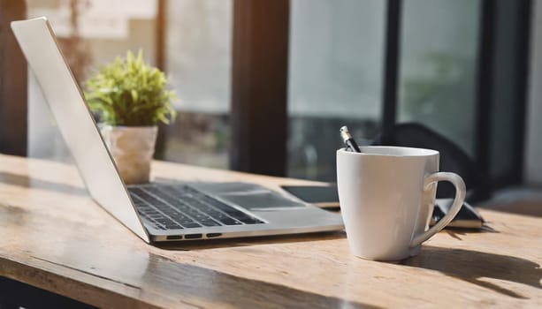 Modern workplace with laptop computer, coffee cup and office supplies