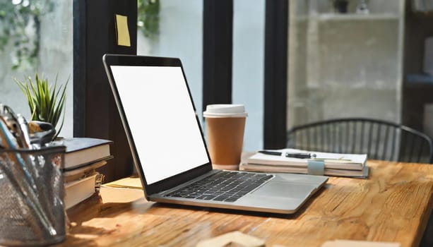 Modern workplace with laptop computer, coffee cup and office supplies