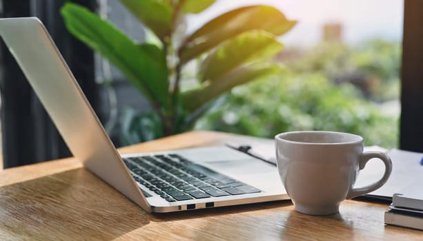 Modern workplace with laptop computer, coffee cup and office supplies