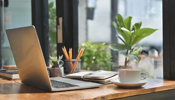 Modern workplace with laptop computer, coffee cup and office supplies