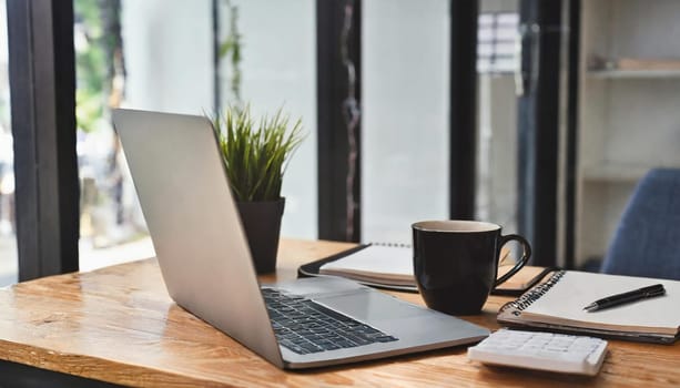 Modern workplace with laptop computer, coffee cup and office supplies